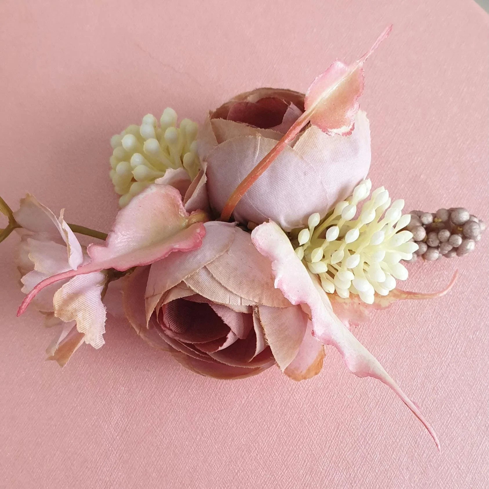 Floral arrangement with pink and beige flowers on a pink background