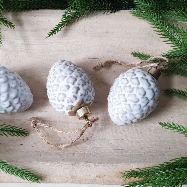 wedding flowers Cheshire - Decorative white textured ornaments on a wooden surface with greenery