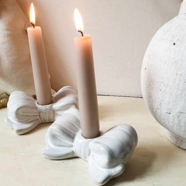 wedding flowers Cheshire - White ceramic candle holder with two lit candles on a neutral background