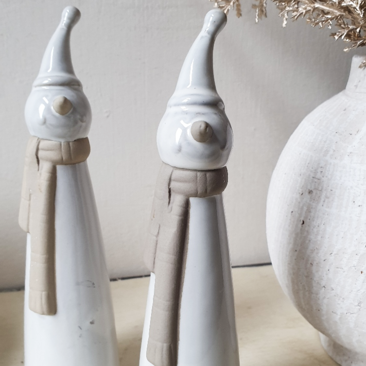 wedding flowers Cheshire - Two ceramic figures with tall hats and scarves on a neutral background