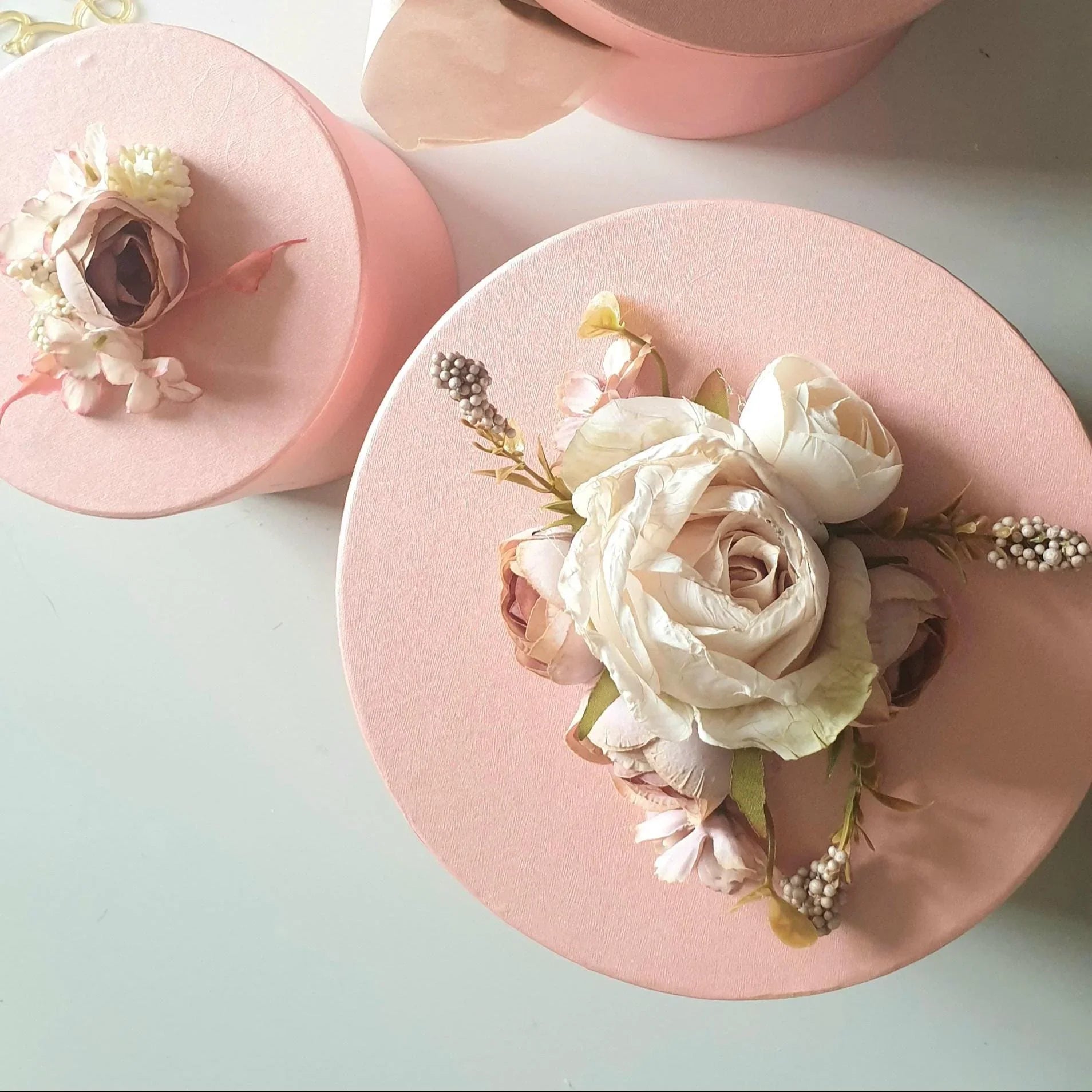 Pink decorative box with floral arrangement on a light blue background