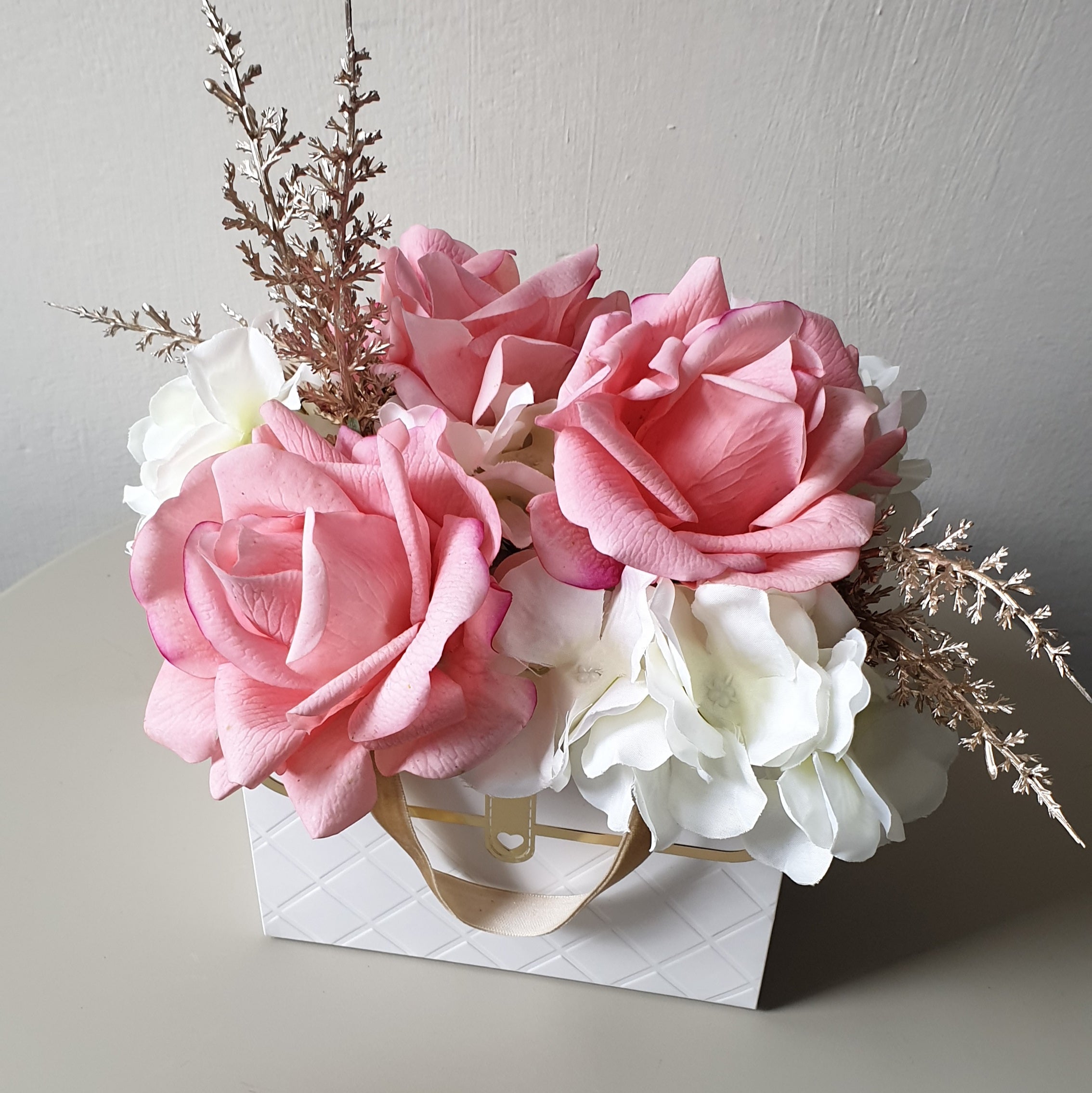 artificial wedding flowers - Bouquet of pink and white flowers in a decorative box on a light background