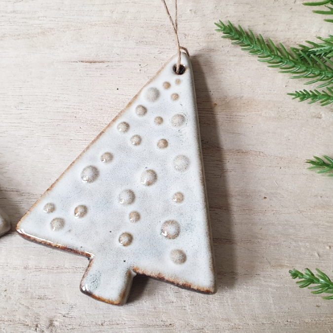 wedding flowers Cheshire - Ceramic Christmas tree ornament with a textured surface on a light wooden background.