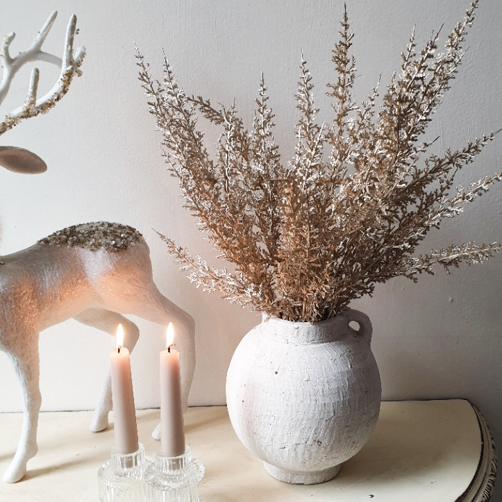 wedding flowers Cheshire - Decorative arrangement with a vase of dried flowers, candles, and a deer figurine on a neutral background.