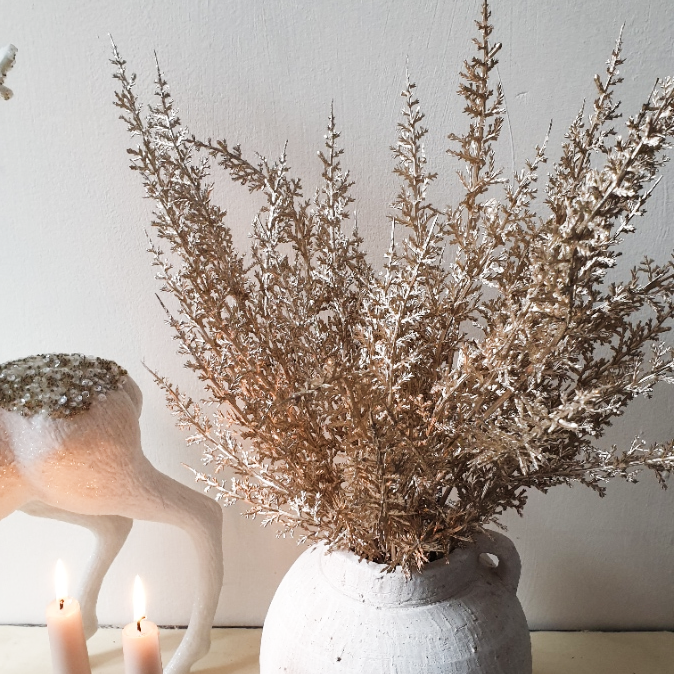 wedding flowers Cheshire - Dried plant arrangement in a white vase with candles and decorative elements on a light background