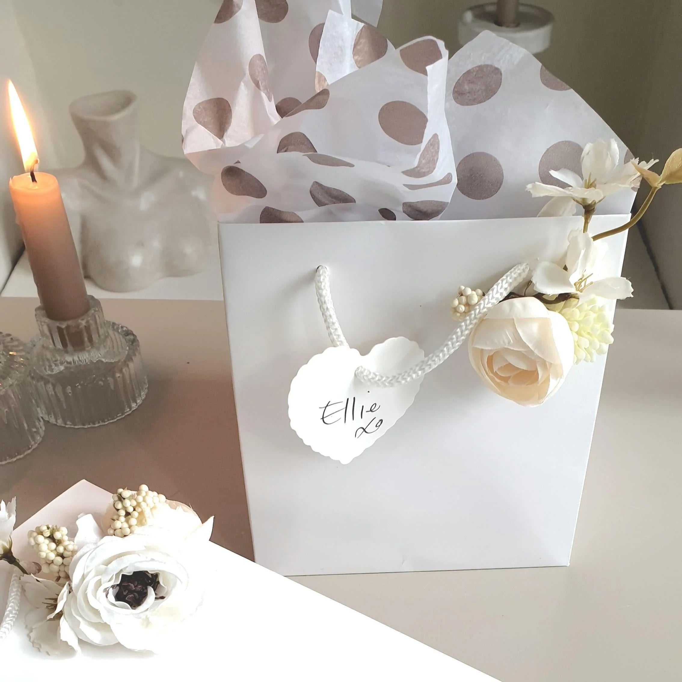 wedding flowers Cheshire - Gift bag with floral arrangement and candle on a table